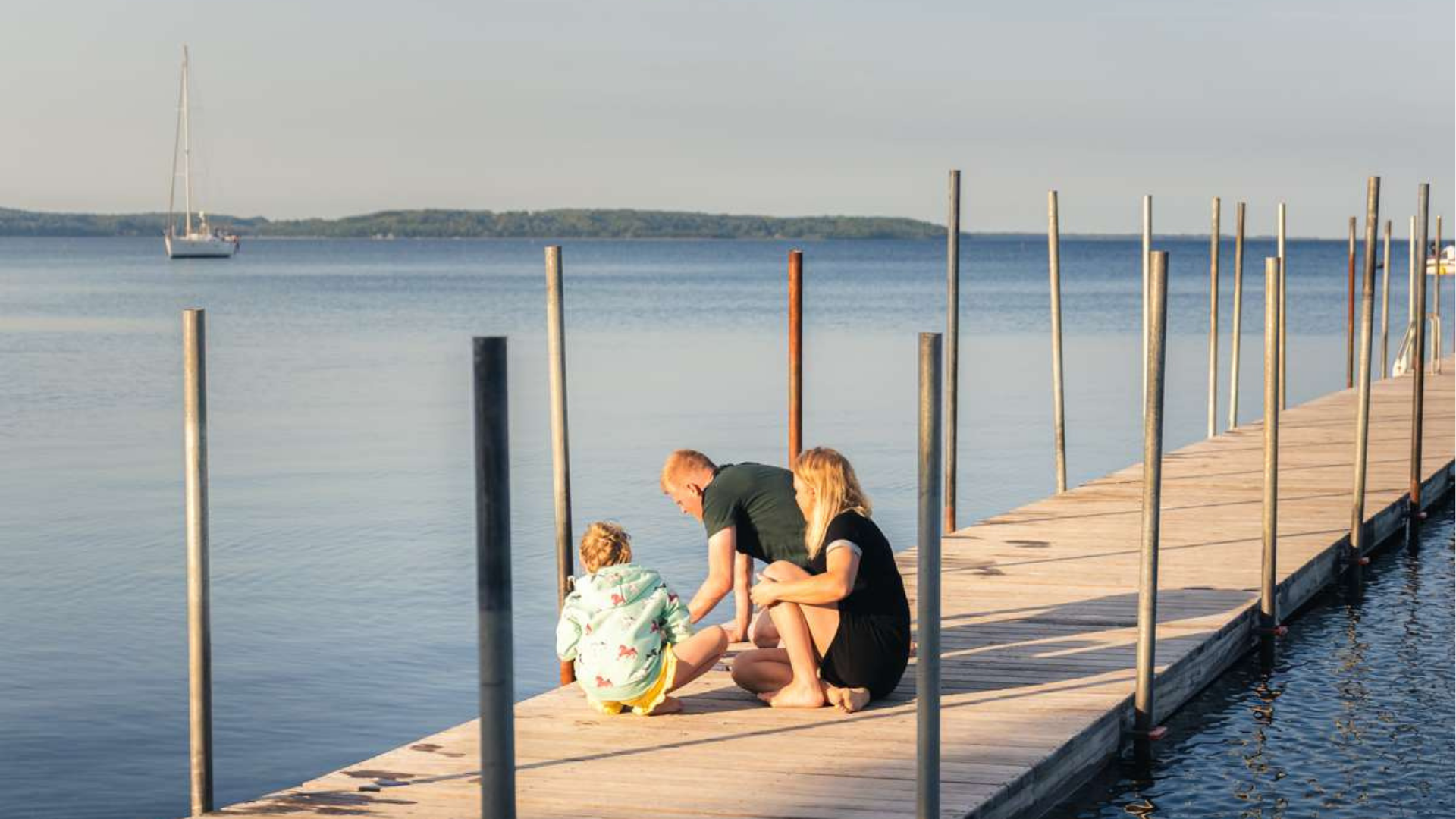 Familie spielt an einem Badesteg an einem Sommertag am Hvidbjerg Strand