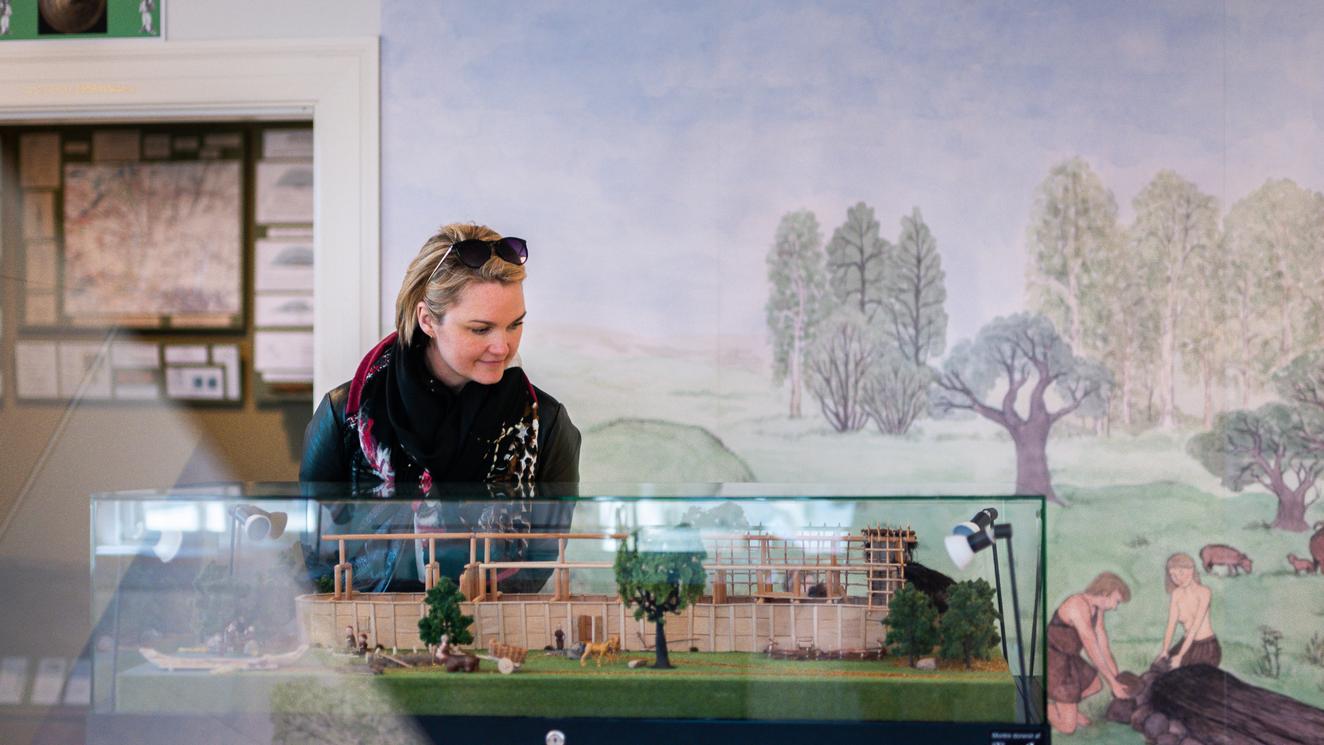 Woman looking at a historical miniature town from the Iron Age at Egtved Museum