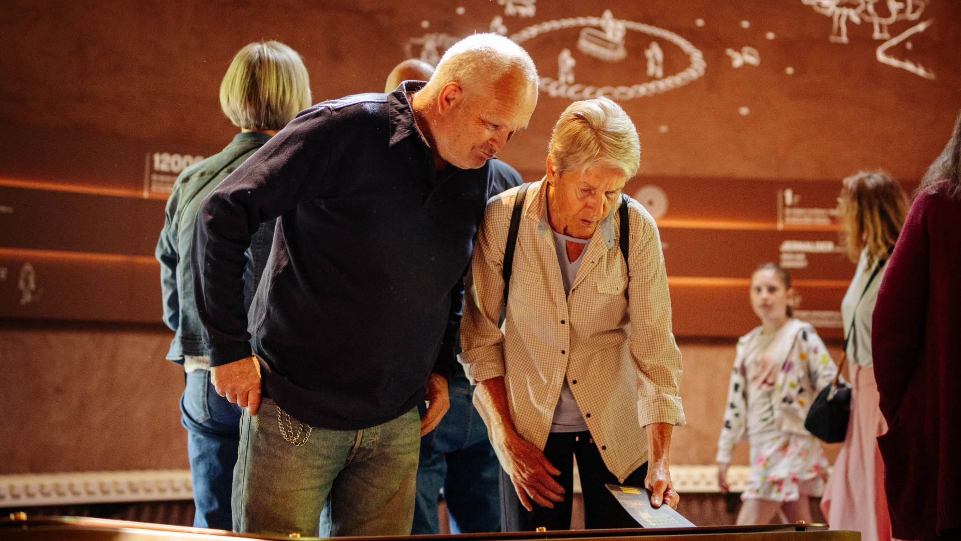 An elderly couple looking at an exhibition about the Egtved Girl in Egtvedpigens Verden