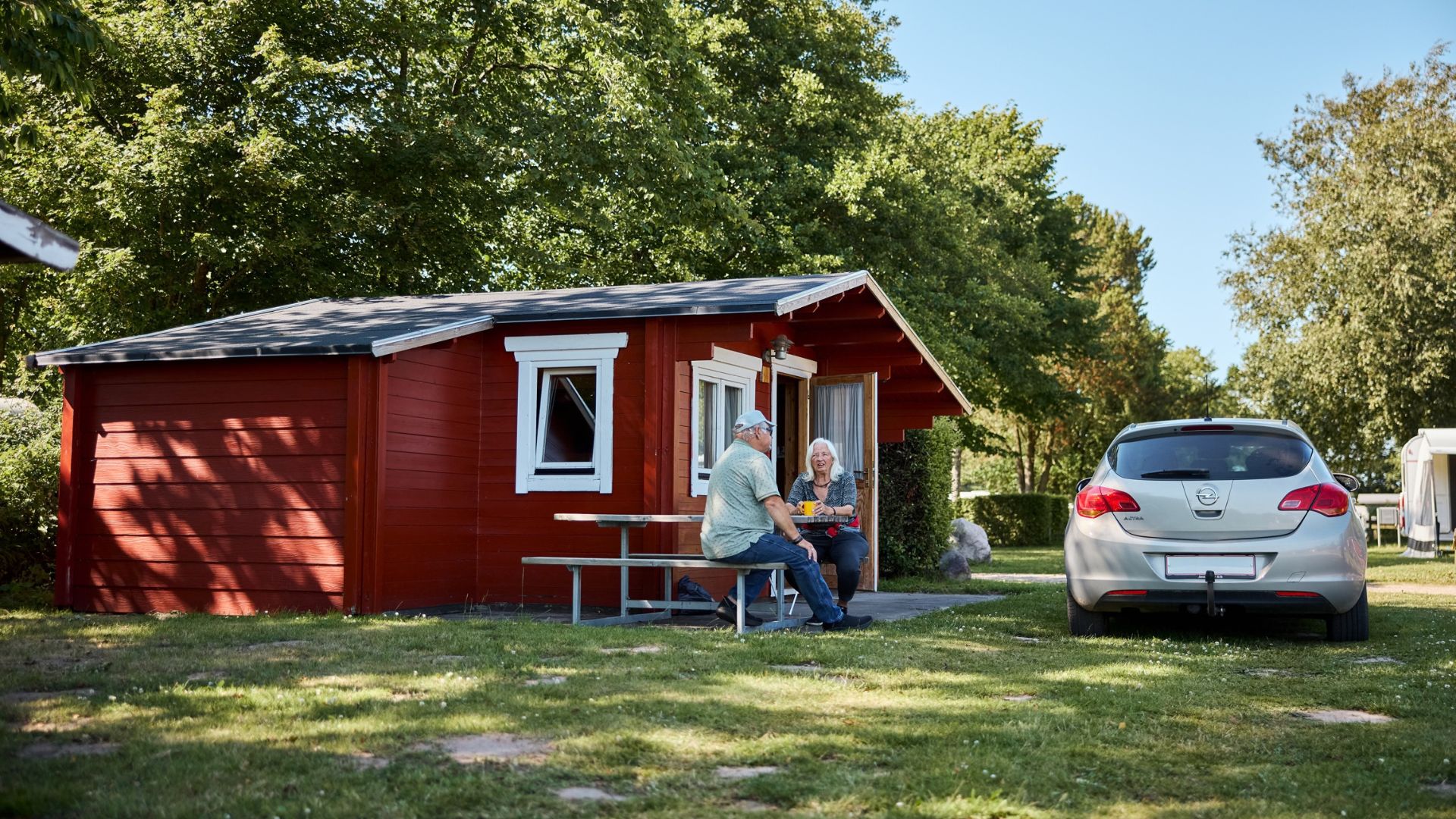 Et par drikker en kop kaffe ved deres hytte på Egtved Camping nær Vejle