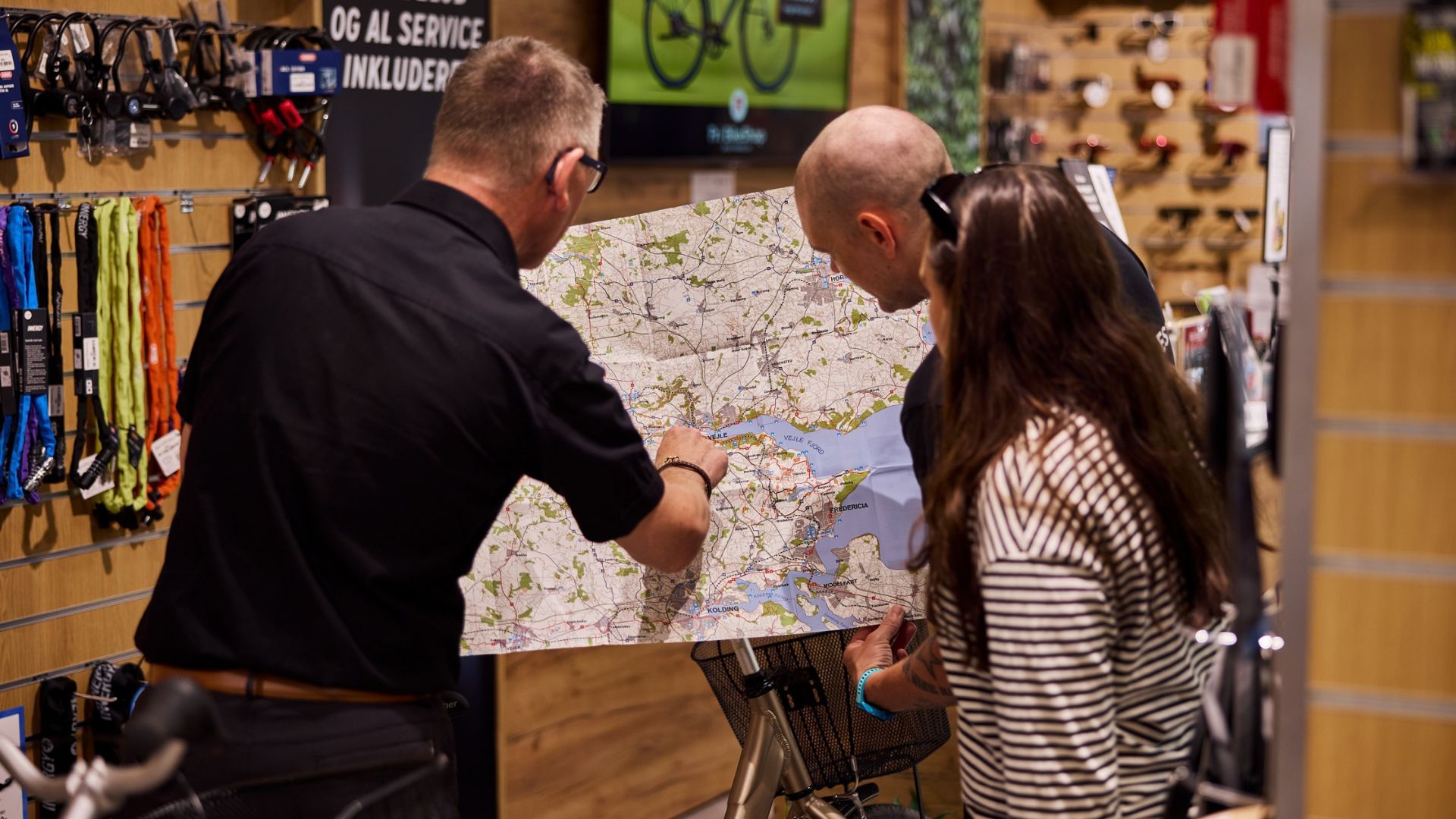 Ejeren af Fri BikeShop i Vejle guider en far og datter ud på en cykelrute i Vejle