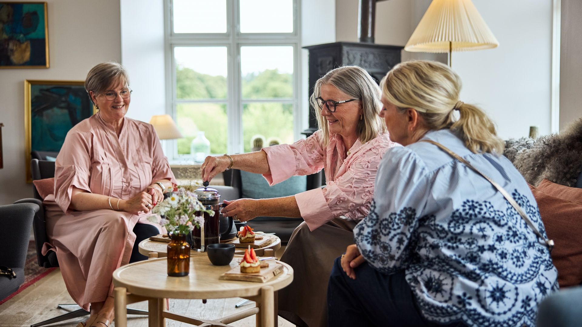 En gruppe kvinder nyder kage og kaffe i loungen på Haraldskær Hotel i Vejle