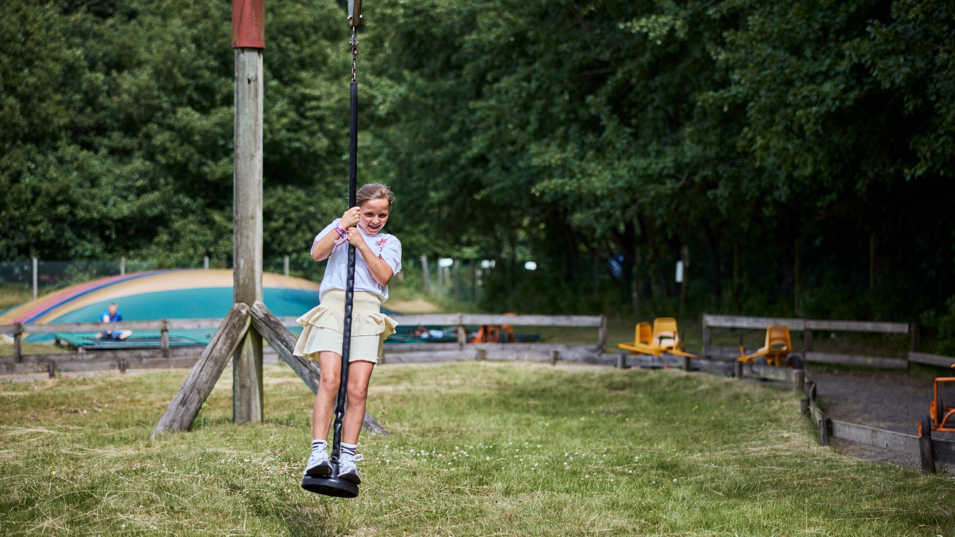 Kinder spielen auf einer Hüpfburg und einer Seilbahn im Riis Feriepark in Give in der Nähe von Vejle.