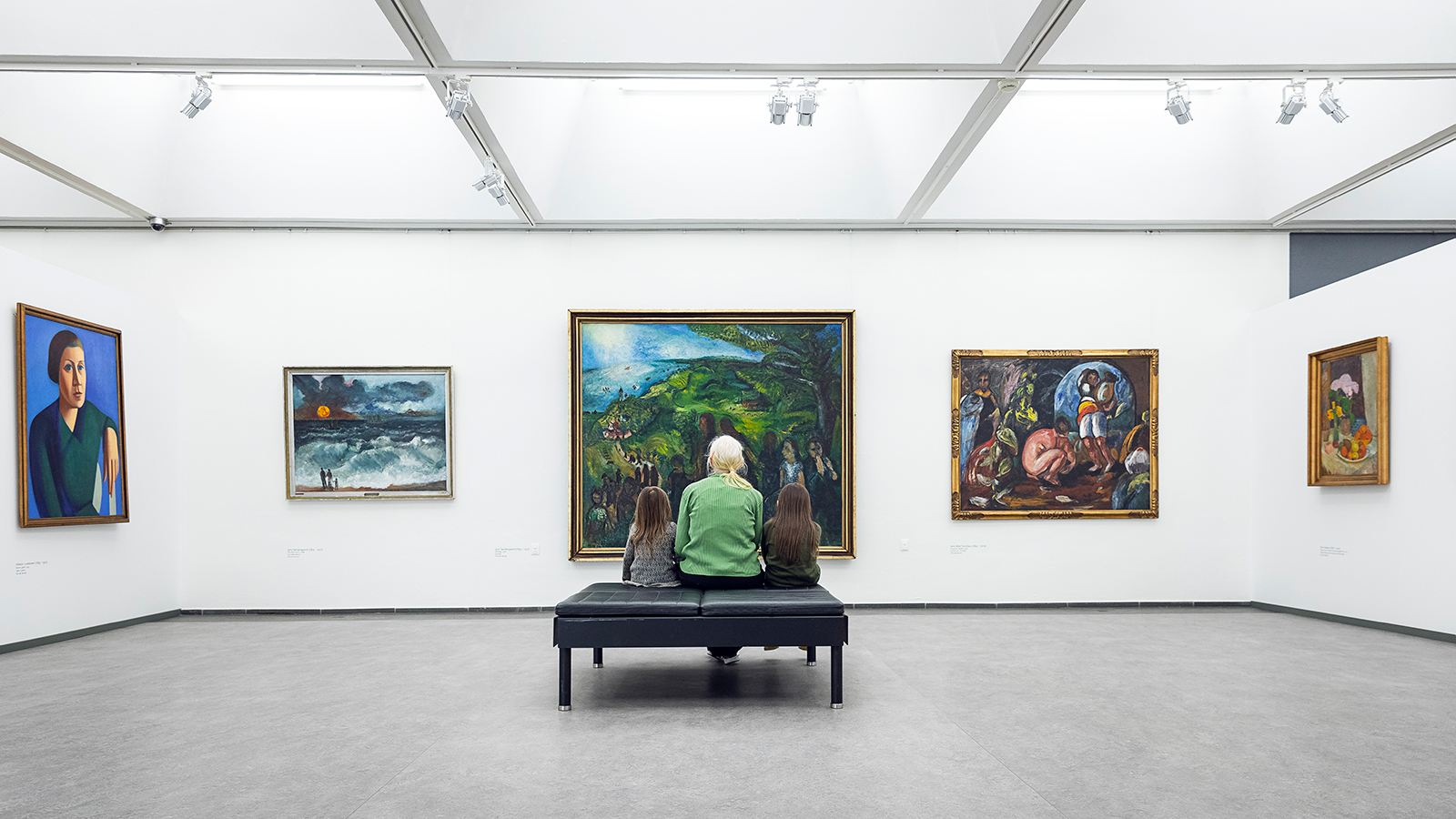 En voksen og to børn kigger på en udstilling på Randers Kunstmuseum