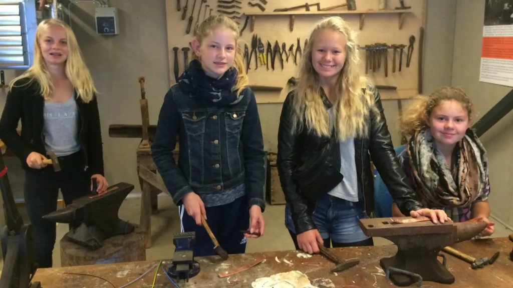 Girls do blacksmithing at the Old Shipyard.