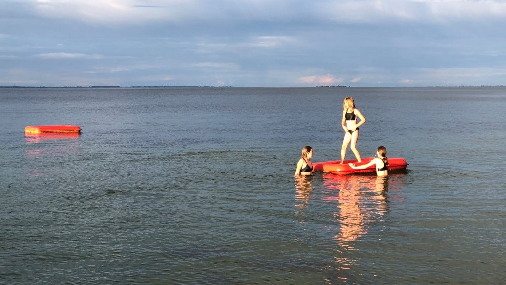 Børn leger på ponton ved Skåret en sommeraften.