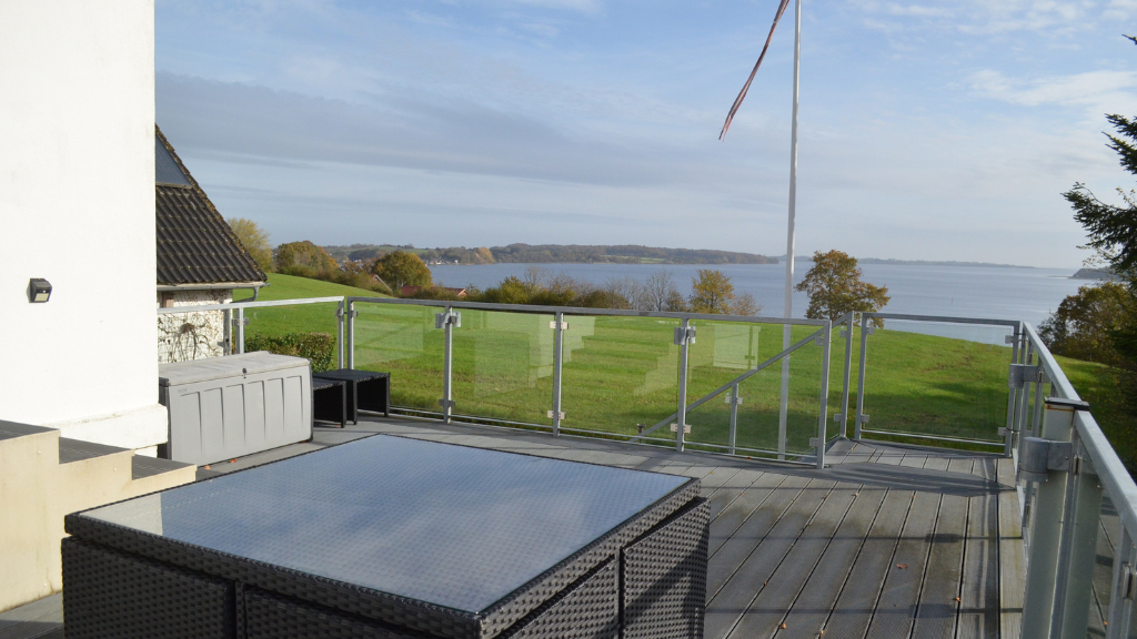 Terrasse mit einem schwarzem Gardentisch und Blick über Genner Bucht