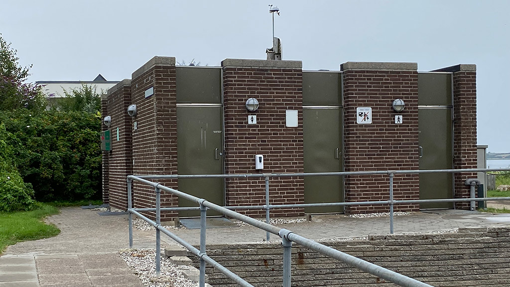Toiletbygning ved Sønderhav med Flensborg Fjord i baggrunden