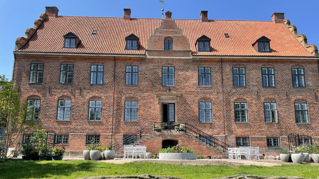 Stor, rød herregård med rødt tag.